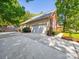 Attached two-car garage with long driveway, brick and siding exterior, and manicured landscaping at 1257 Mill Race Ln, Matthews, NC 28104