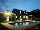 Exterior back view of a house with a pool and a lush backyard at dusk at 12620 Sulgrave Dr, Huntersville, NC 28078
