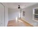 Spacious bedroom featuring hardwood floors, a modern ceiling fan, and large windows at 12620 Sulgrave Dr, Huntersville, NC 28078