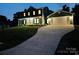 Evening shot of a charming home with a well-lit driveway and attached garage at 12620 Sulgrave Dr, Huntersville, NC 28078