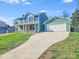 Inviting two-story home with a lush green lawn and a long driveway leading to an attached two-car garage at 12620 Sulgrave Dr, Huntersville, NC 28078