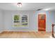 Inviting living room featuring hardwood floors, white walls, and a beautiful wooden front door at 12620 Sulgrave Dr, Huntersville, NC 28078