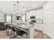 Modern kitchen island with bar stool seating and stainless appliances; open concept to living room at 1316 Colgher St, Mint Hill, NC 28227