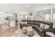 Open-concept living space with a modern sofa, kitchen island, and staircase at 1316 Colgher St, Mint Hill, NC 28227