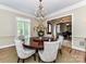 Formal dining room with round table, chandelier, and views of the foyer at 14650 Trading Path Way, Charlotte, NC 28277