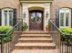 Elegant entryway with brick steps, wrought iron railings, and double wooden doors at 14650 Trading Path Way, Charlotte, NC 28277