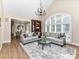 Bright living room featuring hardwood floors, arched window, and elegant chandelier at 14650 Trading Path Way, Charlotte, NC 28277
