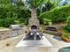 Outdoor kitchen and dining area with stone fireplace and professional grade stainless steel grill at 14650 Trading Path Way, Charlotte, NC 28277