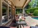 Covered patio with outdoor seating next to a pool and outdoor kitchen with fireplace at 14650 Trading Path Way, Charlotte, NC 28277