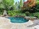 Backyard oasis features a custom pool with waterfall feature and stone surround at 14650 Trading Path Way, Charlotte, NC 28277