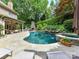 An inviting backyard with custom pool and spa, stone fireplace, and covered patio at 14650 Trading Path Way, Charlotte, NC 28277