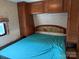 RV bedroom featuring a queen bed with overhead storage and a window for natural light at 148 Sunshine Trl # A165, Mount Gilead, NC 27306