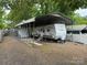 White RV with a metal carport cover with surrounding gravel and additional storage shed at 148 Sunshine Trl # A165, Mount Gilead, NC 27306