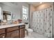 Fresh bathroom showcasing a vanity with dark wood cabinets, and a floral shower curtain at 14925 Baldridge Dr, Huntersville, NC 28078