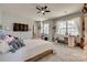 Well-lit bedroom featuring a large bed, two windows, a desk, and a ceiling fan at 14925 Baldridge Dr, Huntersville, NC 28078
