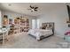 Lovely bedroom featuring a bed with many stuffed animals, a bookcase, and neutral carpet at 14925 Baldridge Dr, Huntersville, NC 28078
