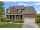 Beautiful two-story brick home with a manicured lawn, covered porch, and two car garage at 156 Pecan Hills Dr, Mooresville, NC 28115