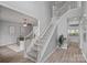 Bright foyer featuring a staircase with white railings, wood floors, and open doorway to the dining room at 156 Pecan Hills Dr, Mooresville, NC 28115