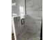Modern shower featuring gray subway tile, a pebble floor, and a glass door at 1640 English Knoll Dr, Matthews, NC 28105