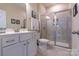 Well-lit bathroom featuring a glass-enclosed shower, neutral tiling, and vanity with sink at 16711 Monocacy Blvd, Huntersville, NC 28078