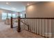 Hallway with carpeted stairs and white banister leading to living area with great natural light at 16711 Monocacy Blvd, Huntersville, NC 28078