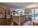 Open-concept kitchen features an island with pendant lighting, stainless steel appliances, and hardwood floors at 16711 Monocacy Blvd, Huntersville, NC 28078