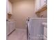 A modern laundry room with white cabinets, sink, and a front load washer and dryer at 16711 Monocacy Blvd, Huntersville, NC 28078
