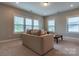 Sunlit living room with neutral color scheme, plush sofa, and a coffee table at 16711 Monocacy Blvd, Huntersville, NC 28078