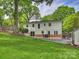 Spacious backyard with lush green grass, mature trees, a small shed, and a patio at 1733 Piccadilly Dr, Charlotte, NC 28211