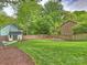 Expansive backyard with lush green grass, privacy fence, and storage shed at 1733 Piccadilly Dr, Charlotte, NC 28211
