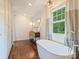 Spacious bathroom with a soaking tub, vanity, and large windows offering natural light at 1733 Piccadilly Dr, Charlotte, NC 28211