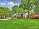 Landscaped home with a sprawling lawn and mature trees creates an inviting curb appeal at 1733 Piccadilly Dr, Charlotte, NC 28211