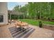 Elegant outdoor patio with pergola, seating area, dining table, and lush green backyard at 1737 Cavaillon Dr, Waxhaw, NC 28173