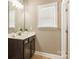 Bathroom with modern vanity, framed mirror, and natural light from window with blinds at 1737 Cavaillon Dr, Waxhaw, NC 28173