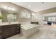 Bright bathroom featuring double vanity, soaking tub with marble surround and tile floors at 1737 Cavaillon Dr, Waxhaw, NC 28173