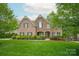 Charming brick home boasts a well-manicured lawn, mature trees, and inviting curb appeal at 1737 Cavaillon Dr, Waxhaw, NC 28173