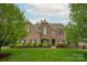Charming brick home boasts a well-manicured lawn, mature trees, and inviting curb appeal at 1737 Cavaillon Dr, Waxhaw, NC 28173