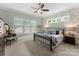 Comfortable bedroom with wallpapered accent wall, neutral carpet, and a ceiling fan at 20614 Pointe Regatta Dr, Cornelius, NC 28031