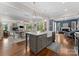 Open-concept kitchen featuring a central island, farmhouse sink, and views into the living and dining areas at 20614 Pointe Regatta Dr, Cornelius, NC 28031