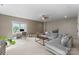 Spacious living room with a gray sectional couch, desk and chair, and large windows for natural light at 20614 Pointe Regatta Dr, Cornelius, NC 28031