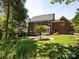 Expansive backyard featuring lush green grass, brick patio, and the house, perfect for outdoor enjoyment at 216 Liriope Ct, Matthews, NC 28105