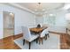 Bright dining room with wood table, modern chandelier, and view into the kitchen at 216 Liriope Ct, Matthews, NC 28105