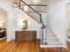 Elegant foyer featuring hardwood floors, staircase with black railing, and stylish decor at 216 Liriope Ct, Matthews, NC 28105