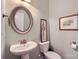 Powder room with pedestal sink, decorative mirror, light-green paint and framed wall art at 2206 Mills Harris Rd, Wingate, NC 28174