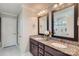 Bathroom featuring double vanity with granite countertop, framed mirrors, and tiled shower at 2206 Mills Harris Rd, Wingate, NC 28174