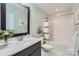 Bright bathroom showcasing a modern vanity, framed mirror, and shower-tub combination at 2206 Mills Harris Rd, Wingate, NC 28174