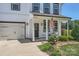 Charming home featuring a welcoming front porch, black door with a wreath, and beautiful landscaping at 2206 Mills Harris Rd, Wingate, NC 28174