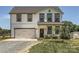 Charming two-story home featuring a white exterior, black trim, an attached garage, and a well-maintained lawn at 2206 Mills Harris Rd, Wingate, NC 28174