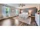 Spacious main bedroom features neutral walls, wood floors, ceiling fan, and two sunny windows at 2206 Mills Harris Rd, Wingate, NC 28174