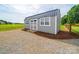 A new storage shed features a dark metal roof, light gray siding, a small wood porch, and matching trim at 2225 Corinth Church Rd, Monroe, NC 28112